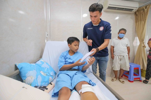 Thủ môn Bùi Tiến Dũng và đội trưởng Văn Thuận sẻ chia với học sinh gặp tai nạn trường THCS Bạch Đằng ảnh 8