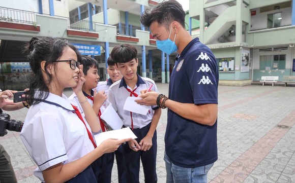Thủ môn Bùi Tiến Dũng và đội trưởng Văn Thuận sẻ chia với học sinh gặp tai nạn trường THCS Bạch Đằng ảnh 5