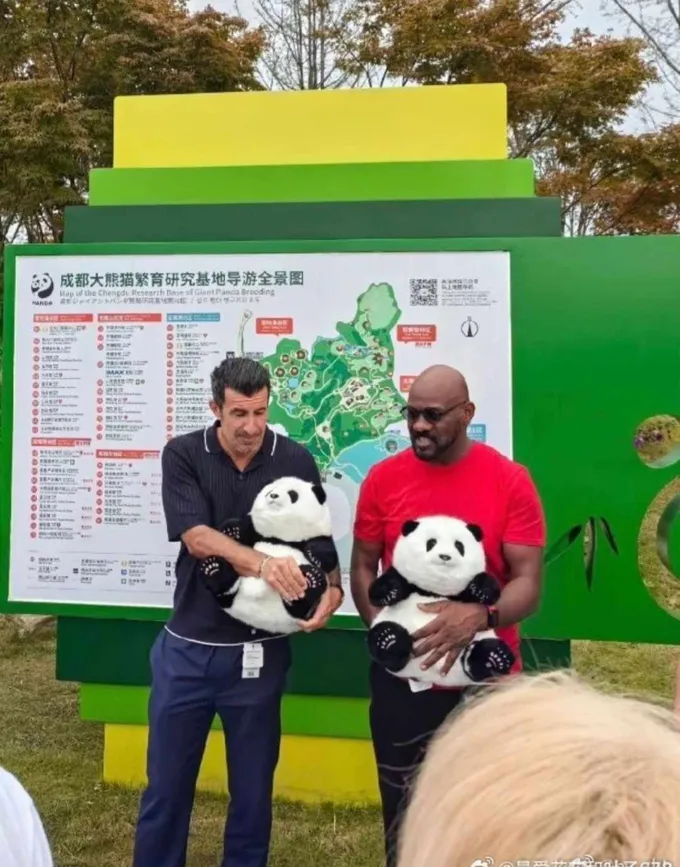 Luis Figo ôm trên tay phiên bản đồ chơi nhồi bông của gấu trúc Hoa Hoa