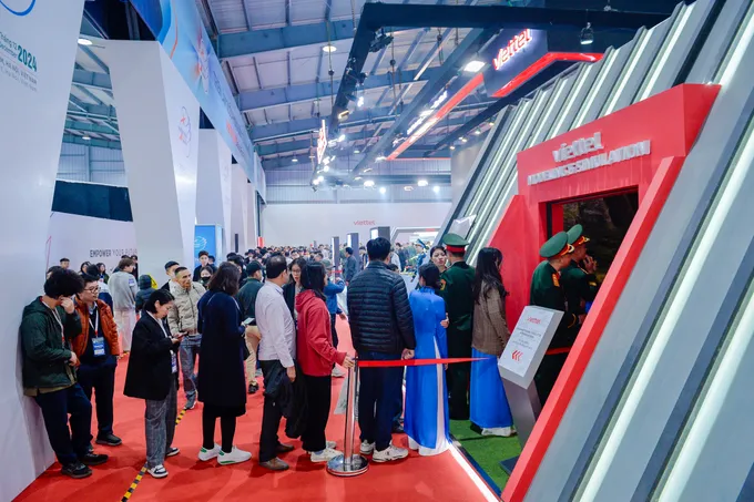Khách tham quan xếp hàng chờ đến lượt trải nghiệm hệ thống mô phỏng bắn súng trong không gian 3D của Viettel tại triển lãm Ban sung 3D-VT 6.jpg