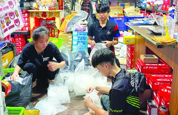 Cửa hàng bán phụ tùng xe gắn máy tại chợ Tân Thành (TPHCM) chuẩn bị hàng giao cho khách đặt mua trên mạng xã hội. Ảnh: HOÀNG HÙNG CN1k.jpg