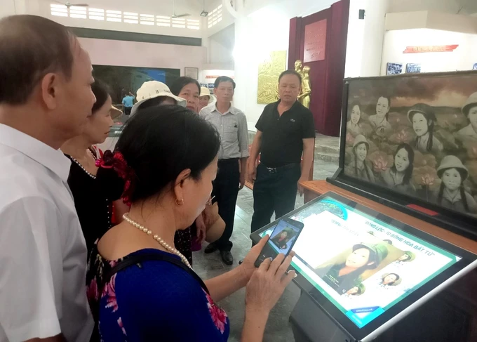 Khách tham quan trải nghiệm màn hình cảm ứng và thiết kế lập trình giới thiệu về Khu di tích Ngã ba Đồng Lộc