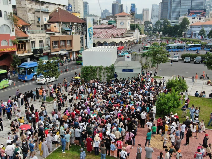 Người dân chờ đợi rất đông bên ngoài ga Bến Thành, chờ lên chuyến tàu metro số 1, ngày 22-12. Ảnh: HOÀNG HÙNG