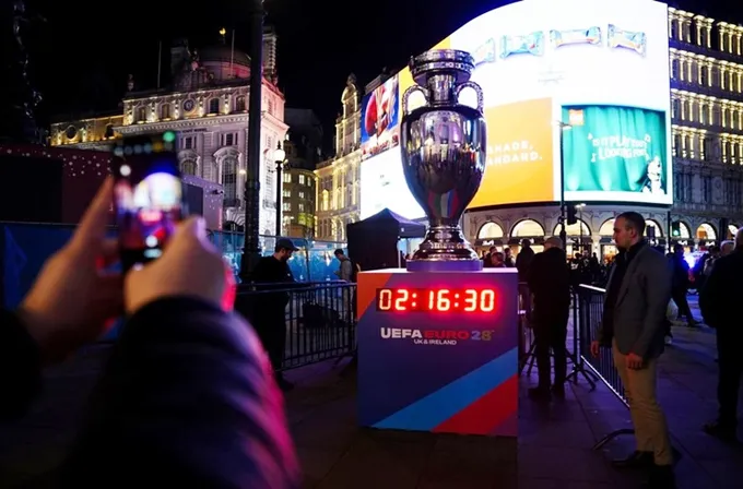 Người hâm mộ chụp ảnh bản sao cúp vô địch châu Âu và đồng hồ đếm ngược đến Euro 2028.