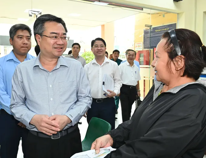 Đồng chí Nguyễn Thanh Nghị hỏi thăm người dân đến làm thủ tục hành chính tại Trung tâm Phục vụ hành chính công phường Bình Hưng Hòa. Ảnh: VIỆT DŨNG f31b8b424309ca579318.jpg