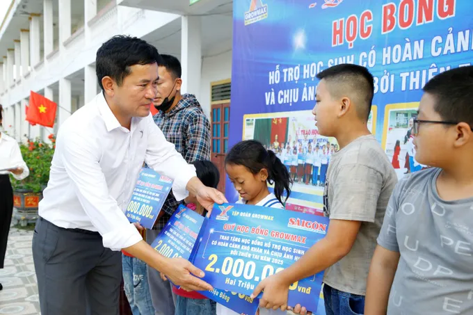Ông Đặng Văn Thành, Giám đốc Khu vực miền Bắc Tập đoàn Growmax, trao học bổng cho các em học sinh 8.JPG