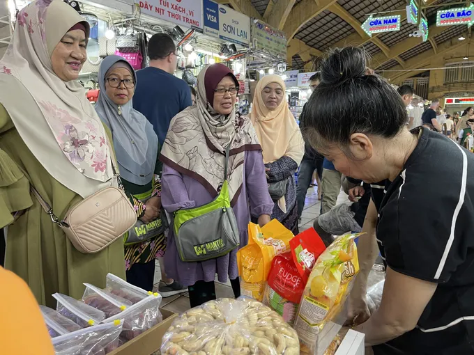 Khách quốc tế chọn mua hàng hóa tại chợ Bến Thành (quận 1, TPHCM). Ảnh: HOÀNG HÙNG chu de.jpg