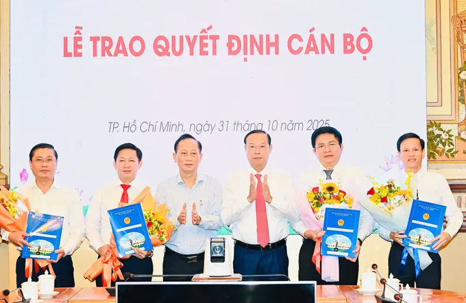 Phó Chủ tịch Thường trực UBND TPHCM Nguyễn Văn Thọ và Phó Bí thư Đảng ủy UBND TPHCM Trần Văn Nam trao quyết định và hoa chúc mừng Ban Giám đốc Trung tâm Phát triển quỹ đất TPHCM. Ảnh: VIỆT DŨNG z7173230073321_08042a70a8d1de194927a24cee7a21c6.jpg