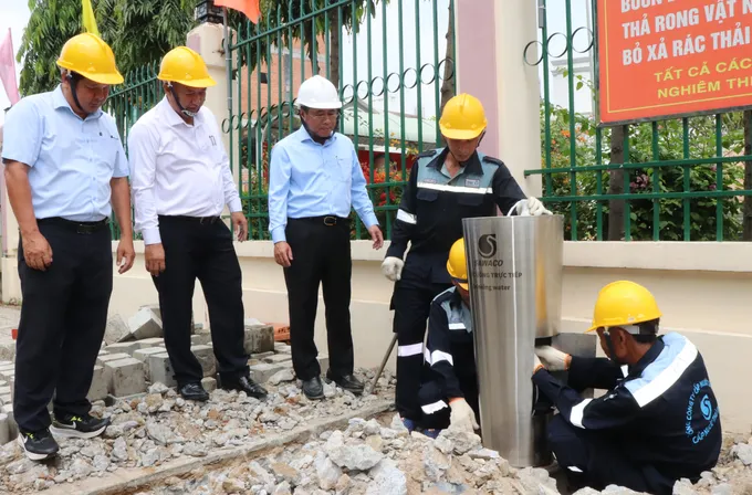 Ông Dương Hồng Nhân, Bí thư Đảng ủy SAWACO (thứ hai từ phải sang) trao đổi cùng công nhân trong quá trình lắp đặt trụ nước uống trực tiếp phục vụ người dân
