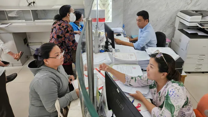 Công chức Trung tâm Phục vụ hành chính công phường Sài Gòn hướng dẫn người dân thực hiện thủ tục hành chính. ẢNH: NGÔ BÌNH