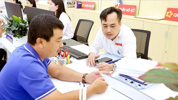 Cán bộ hướng dẫn thủ tục cho người dân tại Trung tâm Phục vụ hành chính công TPHCM (ẢNH: LÊ THOA)