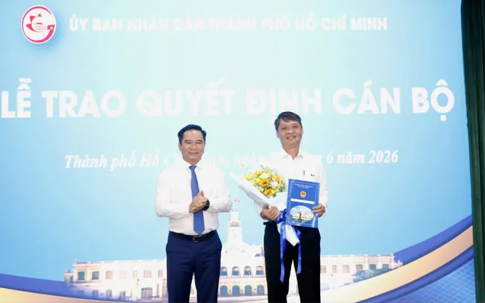 Chủ tịch UBND TPHCM Nguyễn Văn Được trao quyết định nghỉ hưu và tặng hoa đến đồng chí Nguyễn Quốc Chiến. Ảnh: NGÔ BÌNH img-1782705779295-1782705850138-2242-4020.jpg.jpg