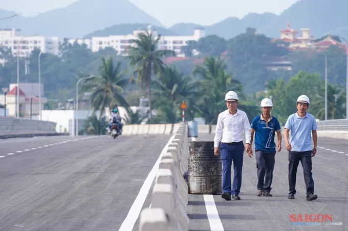 Ông Nguyễn Thanh Hiến (áo trắng), Giám đốc Ban Quản lý Dự án phát triển tỉnh Khánh Hòa, kiểm tra việc cho xe lưu thông sáng 13-2. Ảnh: HIẾU GIANG 1.jpg