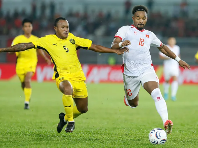 Rodney Celvin (áo vàng) của Malaysia tranh bóng với Xuân Son ở trận lượt đi trên sân Kuala Lumpur. Ảnh: ANH KHOA