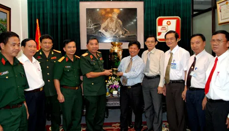 Thượng tướng Bùi Văn Huấn, Ủy viên Trung ương Đảng, Phó Chủ nhiệm Tổng cục Chính trị QĐNDVN tặng quà lưu niệm cán bộ công nhân viên Báo SGGP. Ảnh: ĐỨC TRÍ
