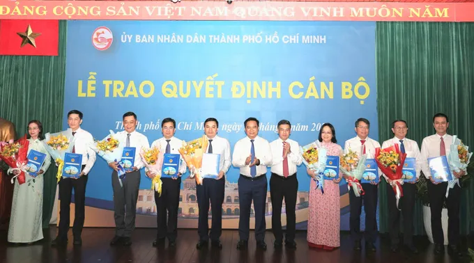 Chủ tịch UBND TPHCM Nguyễn Văn Được, Phó Chủ tịch HĐND TPHCM Nguyễn Văn Dũng trao quyết định và tặng hoa đến cán bộ. Ảnh: NGÔ BÌNH 201b43a92c4cad12f45d.jpg
