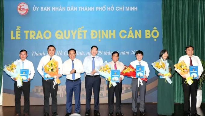Chủ tịch UBND TPHCM Nguyễn Văn Được, Phó Chủ tịch UBND TPHCM Hoàng Nguyên Dinh trao quyết định và tặng hoa đến cán bộ. Ảnh: NGÔ BÌNH IMG_1782705752613_1782705823864.jpg