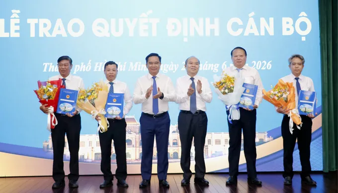 Chủ tịch UBND TPHCM Nguyễn Văn Được, Phó Chủ tịch UBND TPHCM Trần Văn Bảy trao quyết định và tặng hoa đến cán bộ. Ảnh: NGÔ BÌNH IMG_1782705775869_1782705836957.jpg
