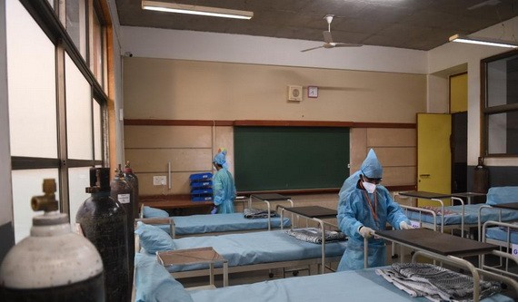 印度古吉拉突邦艾哈默德巴德郊區學校已被改建為新冠護理中心管理員在安排床位。（圖源：互聯網）