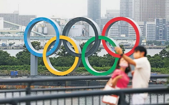 民眾與豎立在東京台場區域的奧運五環標誌合影。（圖源：新華社）