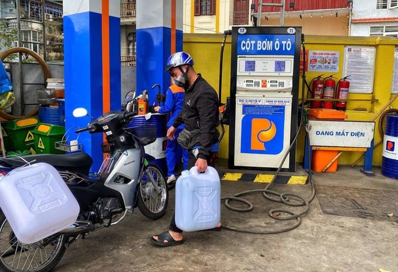 一名河內市民在加油站購買汽油時用塑料桶盛裝汽油。（圖：互聯網）