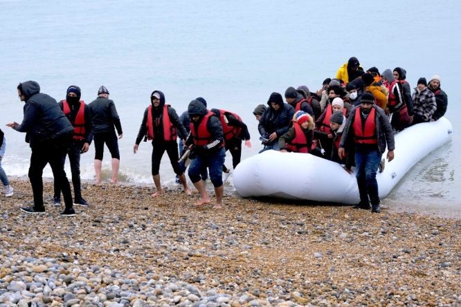 圖為 2021年11月24日，移民乘船抵達英國鄧傑內斯角海岸。（圖：新華社）