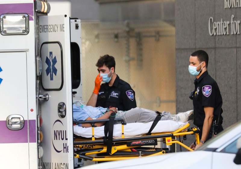 醫護人員在美國紐約一家醫院外轉運病人。（新華社記者王迎攝）