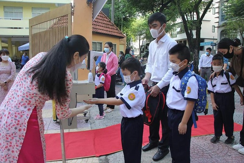 第一郡阮炳謙小學的學生在進入學校前先消毒洗手。