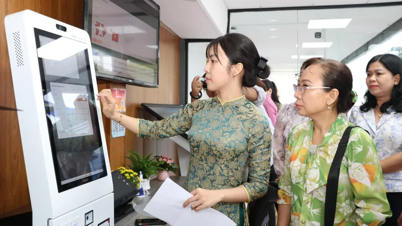 Công chức Trung tâm Phục vụ hành chính công phường Thới An hướng dẫn người dân nộp hồ sơ trực tuyến (ẢNH: NGÔ BÌNH)