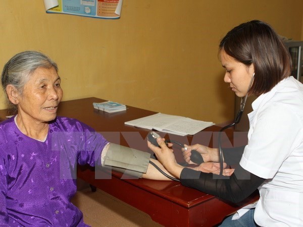 A doctor gives check-up to an elderly woman (Photo: VNA)