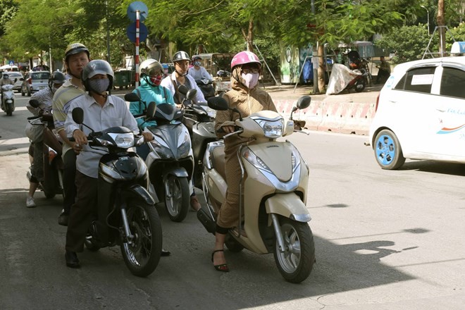 Road users wait for the green light in the shadow to avoid the baking sun at the Truong Chinh - Ton That Tung intersection in Hanoi (Photo: VNA)