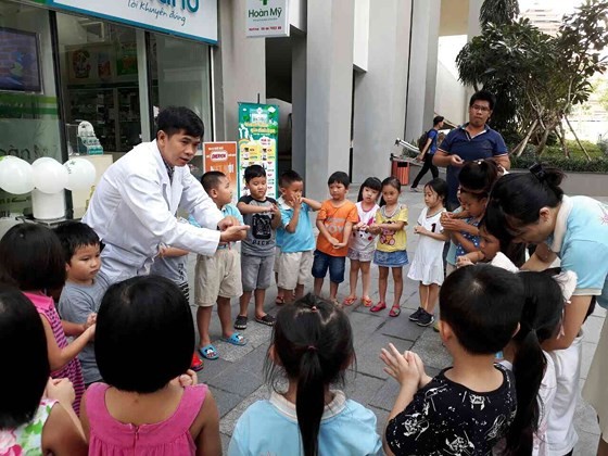 A medical worker is guiding kids of the condominium to wash hand properly (Photo: SGGP)