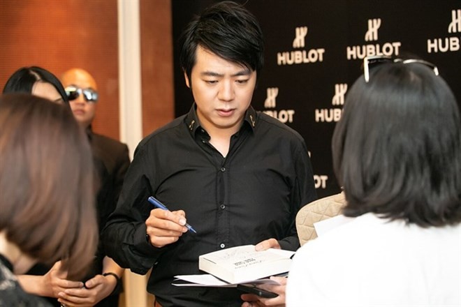 Internationally renowned pianist Lang Lang signs the Vietnamese version of his book today in Hanoi (Photo: VNA)