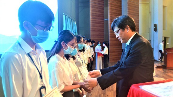 Deputy Director of the National University of Ho Chi Minh City Nguyen Minh Tam awards scholarships to students with financial difficulties and good performance (Photo: SGGP)