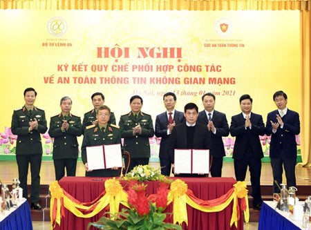 Lieutenant General Dinh The Cuong and Head of AIS Nguyen Thanh Phuc are signing the Regulation. (Photo: SGGP)