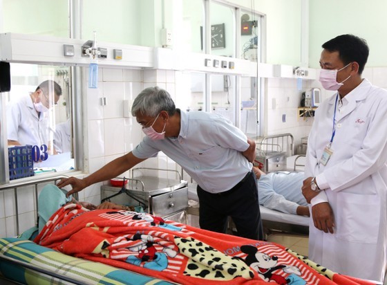 Deputy chairman of HCMC People’s Committee Vo Van Hoan (L) visits patients at a hospital in Binh Phuoc Province (Photo: SGGP)