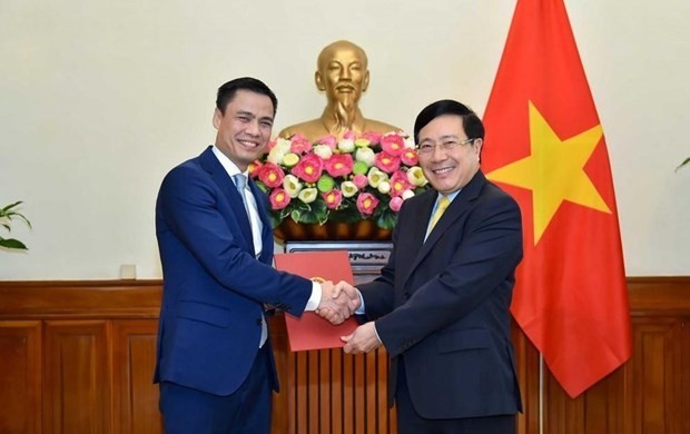 Deputy Prime Minister and Foreign Minister Pham Binh Minh (right) presents the decision to Deputy Foreign Minister Dang Hoang Giang. (Photo: Baochinhphu.vn)