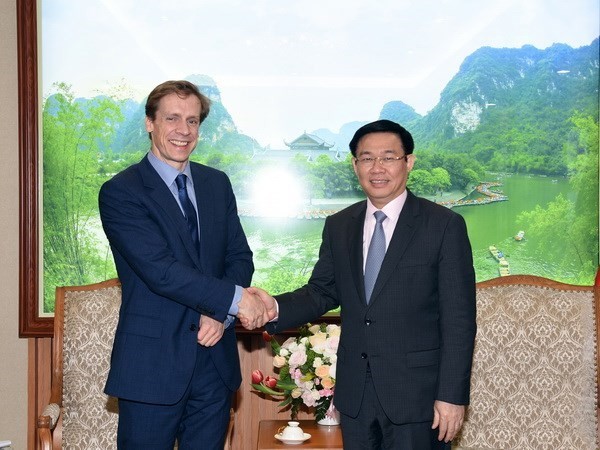 Deputy Prime Minister Vuong Dinh Hue (R) greets Justin Wood, head of the Asia-Pacific region of the WEF. (Photo: VNA)
