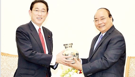 PM Nguyen Xuan Phuc ( R) presents a souvenir to Mr. Fumio Kishida