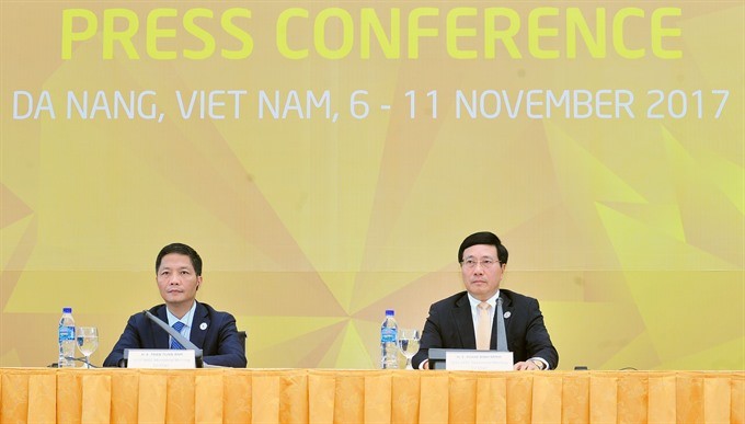 Deputy PM and Foreign Minister Pham Binh Minh and Minister of Industry and Trade Tran Tuan Anh co-chair a press conference at the International Media Centre in Da Nang City on Thursday. (Photo: VNA/VNS)