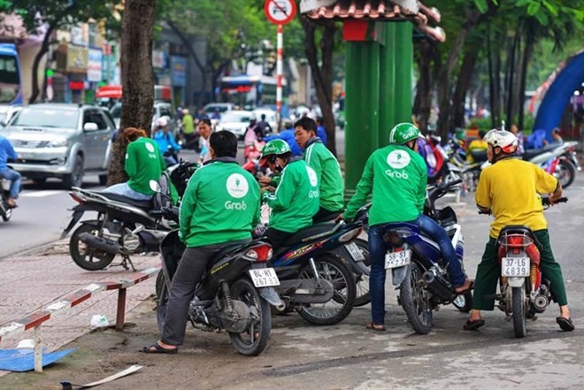 Vietnamese Grab bike riders wait for passengers in HCM City. (Photo: vietcetera.vn)