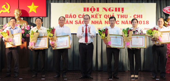 HCMC Party Chief Nguyen Thien Nhan gives certificates of merit to representatives of 24 districts for well fulfilling their budget revenue mission in 2018 on January 3 (Photo: SGGP)