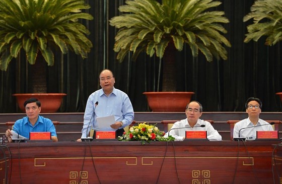 PM Nguyen Xuan Phuc (standing) at the meeting with highly-skilled workers in HCMC. (Photo: VNA)