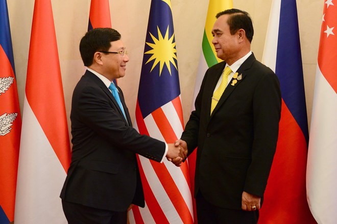 Vietnamese Deputy Prime Minister and Foreign Minister Pham Binh Minh (L) shakes hands with Thai Prime Minister Prayut Chan-o-cha at the meeting in Bangkok on July 31 (Photo: VNA)