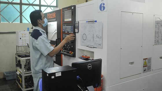 A worker operates CNC machine in Duy Tan Plastic Company. (Photo: SGGP)