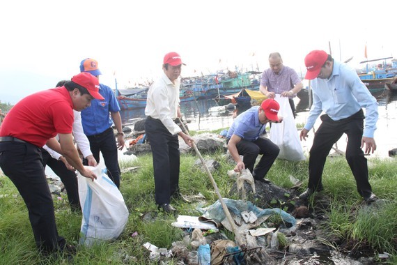 Deputy minister of the Ministry of Natural Resources and Environment participates in the program to clean the beach. (Photo: SGGP)