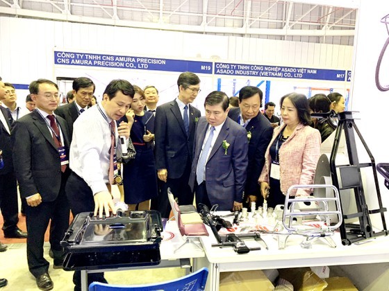 Mr. Nguyen Thanh Phong, Chairman of the Ho Chi Minh City People's Committee, exchanges with domestic enterprises about the capability of supplying supporting industry products for FDI enterprises. (Photo: SGGP)