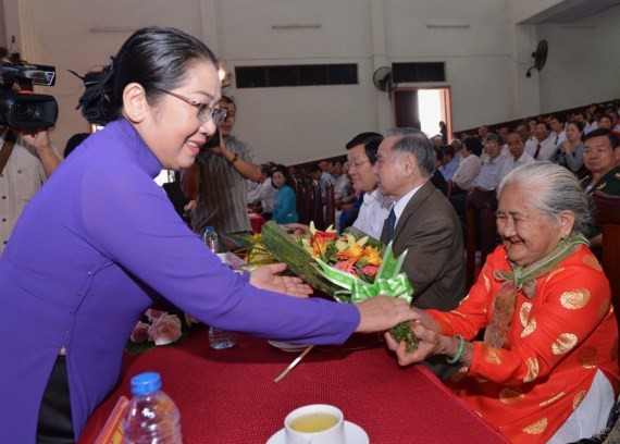 HCMC deputy Party Secretary Vo Thi Dung offers flowers to a Vietnamese heroic mother at the ceremony. (Photo: Sggp)