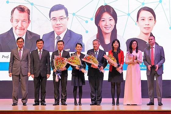 Vice Chairwoman of the municipal People’s Committee Nguyen Thi Thu (in Ao Dai) congratulates scientists in the award ceremony. (Photo: Sggp)