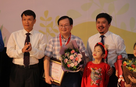 Children author Nguyen Nhat Anh (C) receives the Cricket Knight prize.